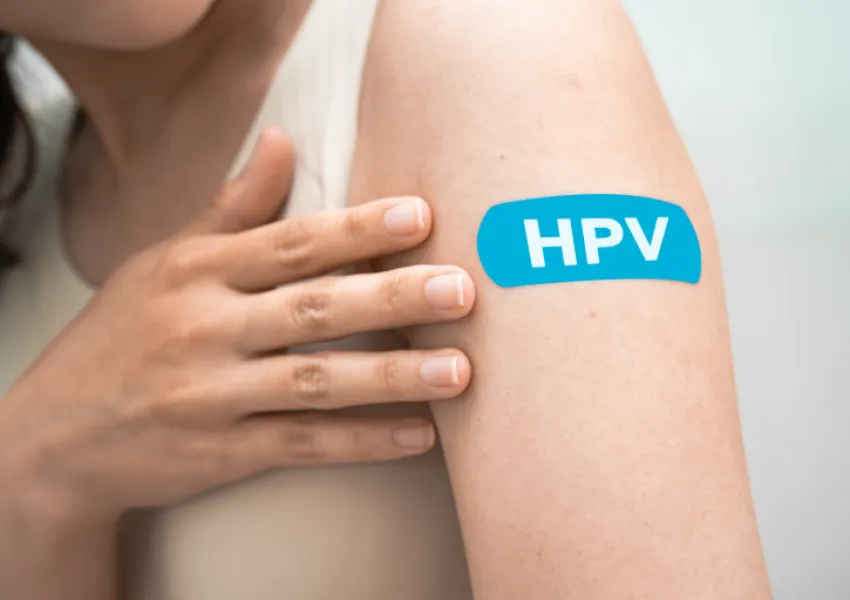 The top of someone's arm, on which there is a plaster with the lettering 'HPV'.