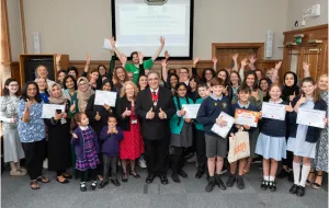 A group photo of the healthy schools celebration with hands in the air, teachers, students and the Deputy Mayor of Barnet