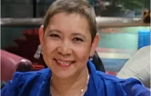 Woman wearing blue blouse smiling to camera