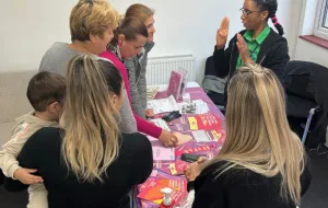 Picture of a female speaking & raising cancer awareness to a group of females.