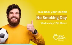 Smiling man with football giving a thumbs up
