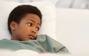 A sick child lying in bed