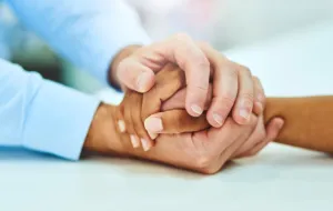 Somebody holding someone else's hand in their hands.