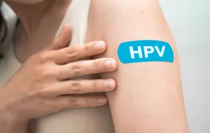 The top of someone's arm, on which there is a plaster with the lettering 'HPV'.