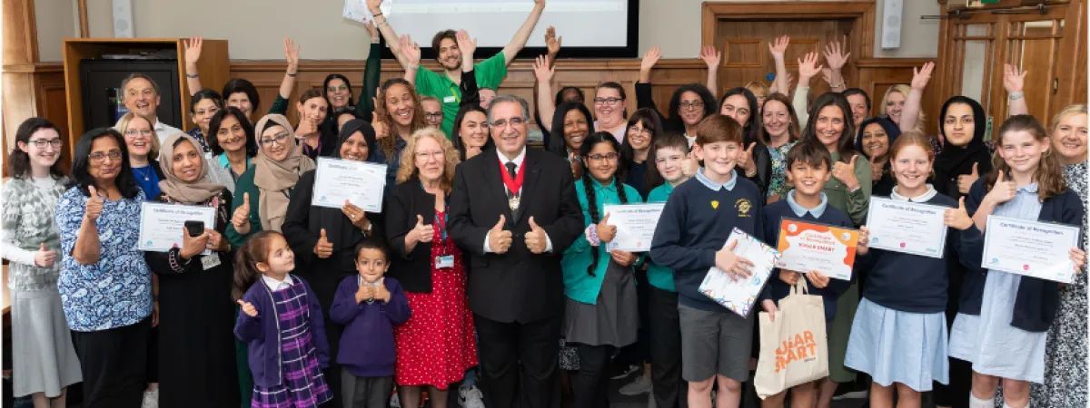 A group photo of the healthy schools celebration with hands in the air, teachers, students and the Deputy Mayor of Barnet