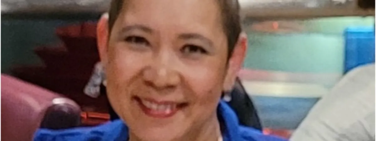 Woman wearing blue blouse smiling to camera