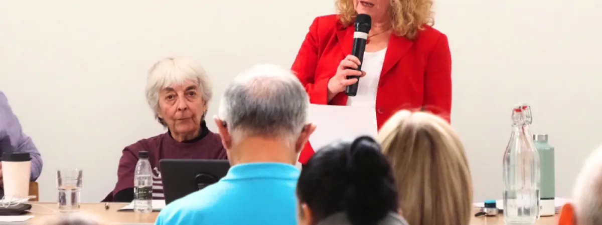 Cllr Alison Moore speaking into a microphone to the audience at the Barnet Food Summit