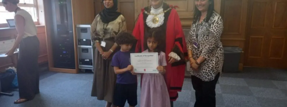 The mayor awarding certificates to children