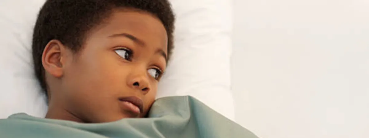 A sick child lying in bed
