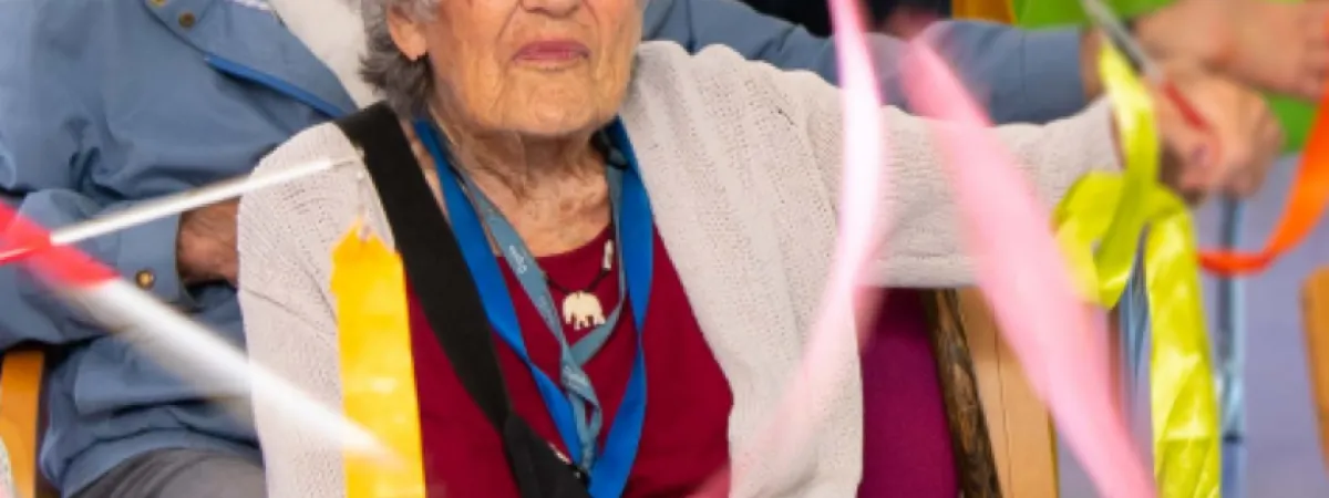 Lady sitting in a chair with ribbons around her.