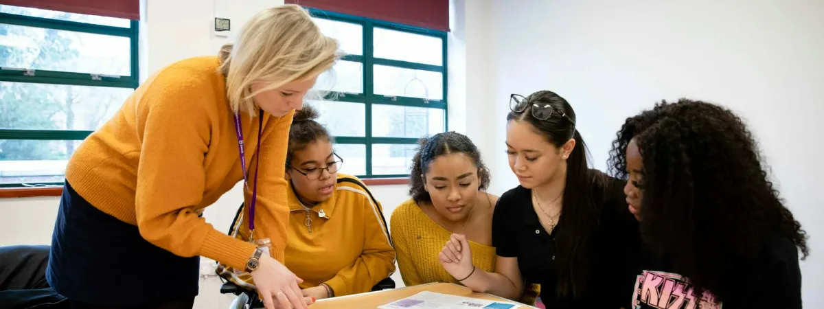 A female teacher talking to young people