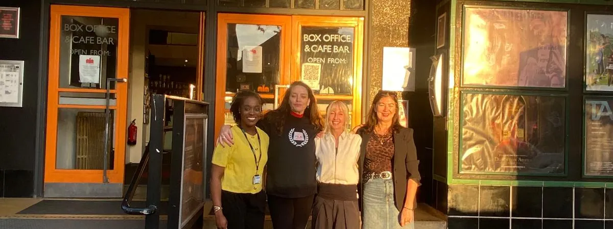 Four people standing outside the cinema