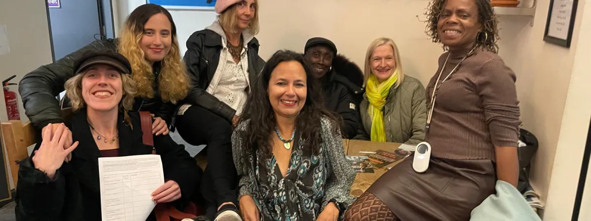 A group of people sitting and standing together smiling