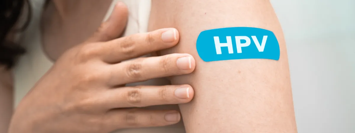 The top of someone's arm, on which there is a plaster with the lettering 'HPV'.